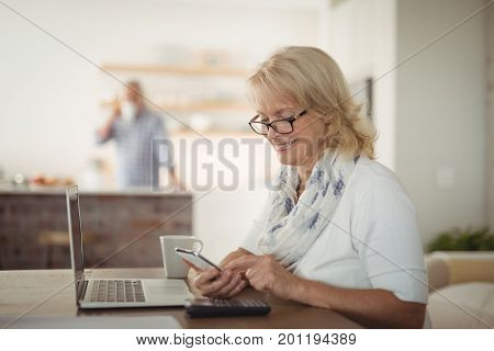 Senior woman using mobile phone at home