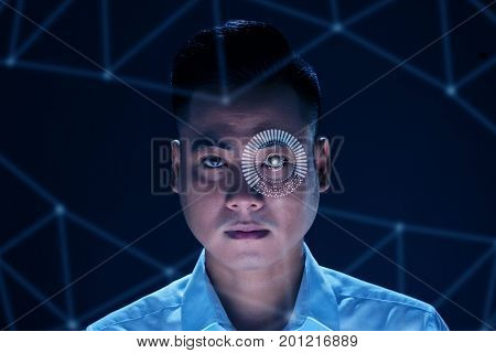 Face of Vietnamese man using modern technology to scan his retina