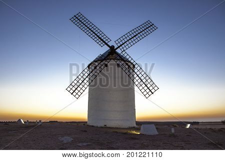Illuminated traditional windmill at rising Campo de Criptana Spain