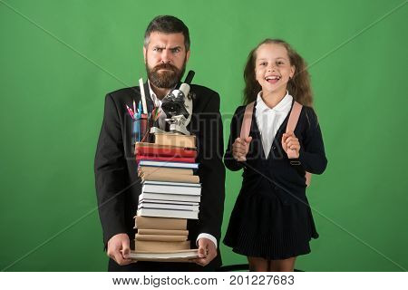 Kid And Dad Hold Pile Of Books With School Supplies