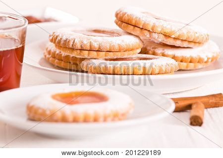 Teatime biscuits with jam on white dish.