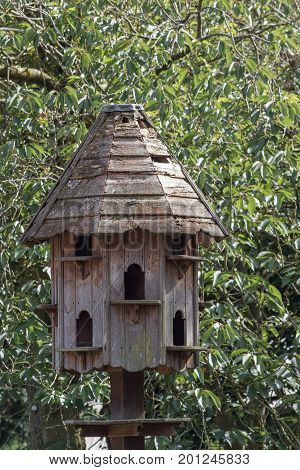 Traditional wooden dovecote. Free-standing dovecot. Weathered wood house for doves and pigeons.