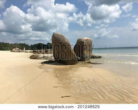 Prominent rock duo between sand and see on white sand beach