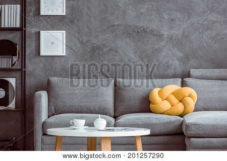 Grey Settee Against Concrete Wall