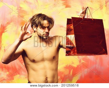 Caucasian Bearded Sexy Macho Man Holding Red Package Or Bag