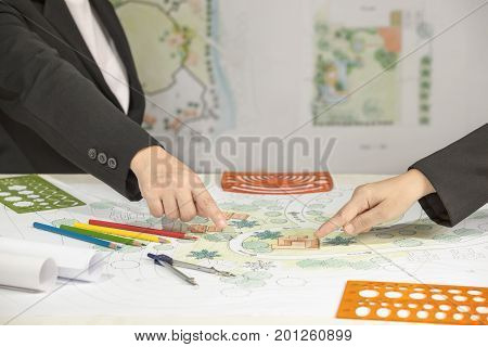 Landscape architect changing drawing at meeting with client