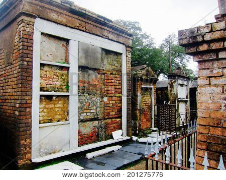 Old, weathered colored brick above ground graves