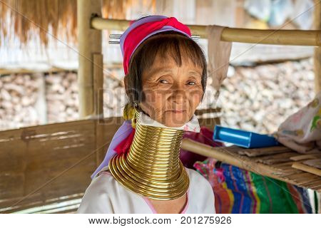 CHIANG MAI, THAILAND - July 10, 2017: Karen hill-tribe (Long Neck) woman weaving fabrics for a living at her house.