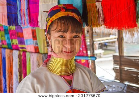 CHIANG MAI, THAILAND - July 10, 2017: Karen hill-tribe (Long Neck) woman weaving fabrics for a living at her house.