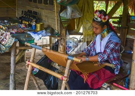 CHIANG MAI, THAILAND - July 10, 2017: Karen hill-tribe (Long Neck) woman weaving fabrics for a living at her house.