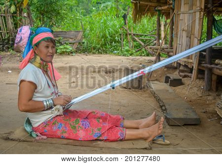 CHIANG MAI, THAILAND - July 10, 2017: Karen hill-tribe (Long Neck) woman weaving fabrics for a living at her house.