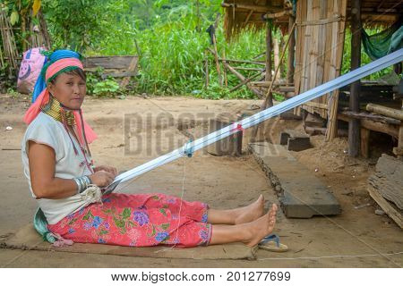 CHIANG MAI, THAILAND - July 10, 2017: Karen hill-tribe (Long Neck) woman weaving fabrics for a living at her house.