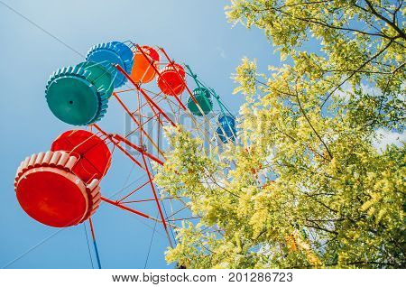 Brightly Colored Ferris Wheel Against The Blue Sky