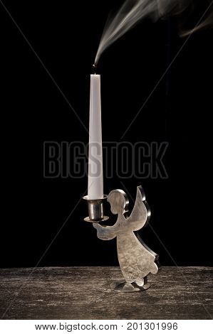 smoke candle in vintage candlestick on black background