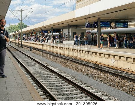 MANNHEIM GERMANY - AUG 8 2017: Large group of people waiting at the train station platform in Mannheim hauptbahnhof Train station commuting in German waiting for the delayed train