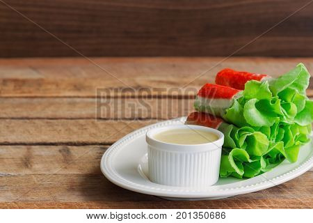 Fresh spring rolls with fresh vegetable and crab stick served with spicy salad cream dipping sauce. Rolls salad or fresh spring roll on white plate healthy delicious food for appetizer or meal. Fresh spring rolls in fusion food style.