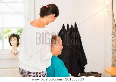 Female Hairdresser Cutting Hair Of Man