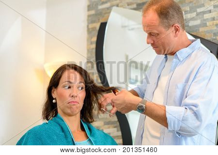 Hairdresser Cutting Hair Of Woman