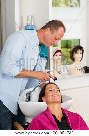 Hairdresser Washing Hair Of Woman