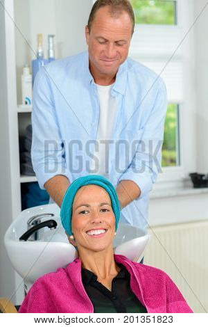 Hairdresser Washing Hair Of Woman