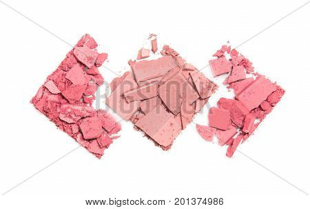 Pieces of scattered compact powder on white background in the form of three rhombuses