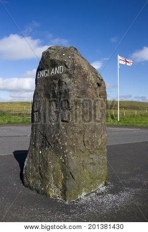 English flag and rock with England painted on it marking the Scottish - English Border Northumberland United Kingdom