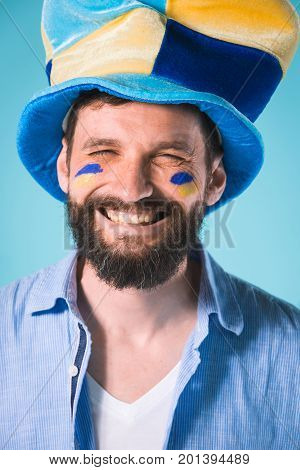 The emotions on face of football fan with hat over blue background