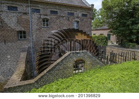 Old historically large rusted metal blade wheel of a water mill
