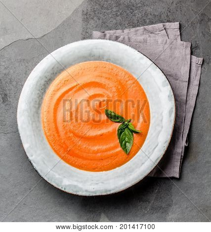 Traditional spanish andalusian tomato cream soup - salmorejo. Salmorejo or gazpacho cream soup on gray bowl, slate gray background.