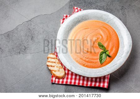 Traditional spanish andalusian tomato cream soup - salmorejo. Salmorejo or gazpacho cream soup on gray bowl, slate gray background.