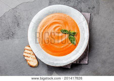 Traditional spanish andalusian tomato cream soup - salmorejo. Salmorejo or gazpacho cream soup on gray bowl, slate gray background.