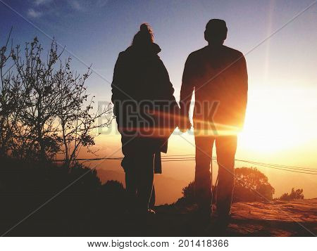 Silhouette of Young Romantic Couple Holding Hands at Amazing Golden Sunset. Carefree Travel Lyfestyle Relationship Concept.