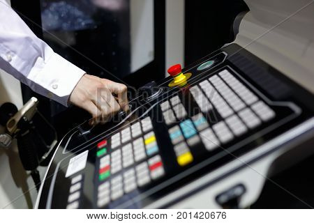 The operator controls the operation of the CNC machine center. Selective focus.