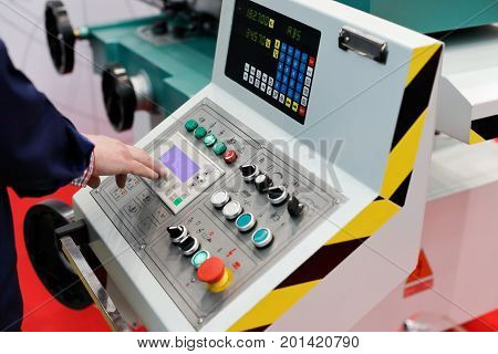 Operator working with control panel of cnc turning and milling machine. Selective focus.