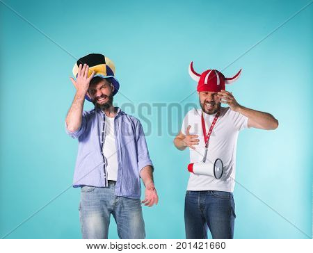 The two football fans with emotions of disappointment over blue background