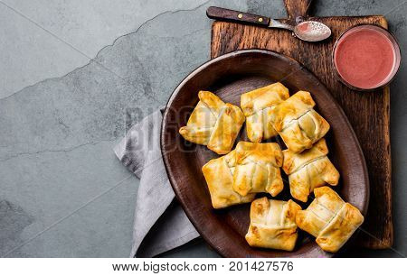 Mini chilean empanadas on clay plate with typical chilean drink vino con harina - red wine with toasted flour.