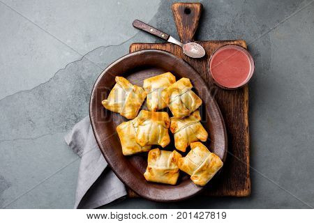 Mini chilean empanadas on clay plate with typical chilean drink vino con harina - red wine with toasted flour.