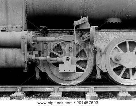 wheels on an old rusting abandoned steam locomotive with missing parts on tracks