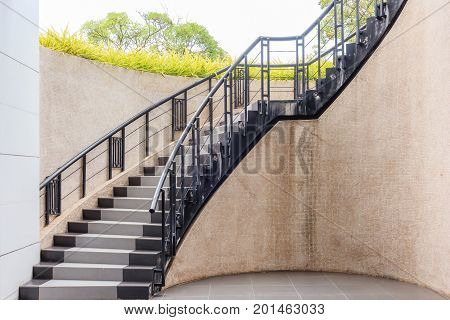 Outdoor stone staircase. Stone steps of old staircase with metal fence. Exterior design in vintage style.