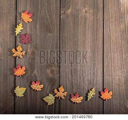 Wooden autumn leaves in a corner pattern on wood with blank space