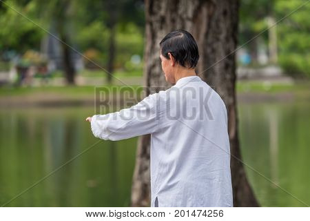 Man Exercising By Tai Chi In A Outdoor Park