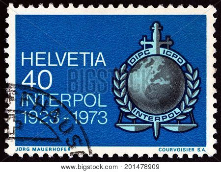 SWITZERLAND - CIRCA 1973: A stamp printed in Switzerland issued for the 50th anniversary of International Criminal Police Organization (Interpol) shows Interpol emblem, circa 1973.