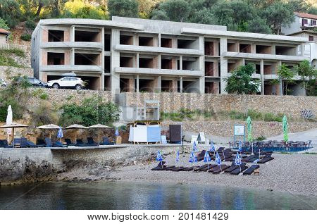 ULCINJ, MONTENEGRO - JULY 30, 2017: Small rock beach Liman on the Adriatic Sea in Ulcinj, Montenegro. Early morning time with empty beach beds, closed umbrellas and without people.