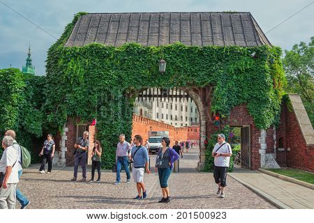 Krakow/Poland- August 14, 2017: Wawel Royal Castle, tourists entering the palace complex main gate, covered by overgrown green ivy
