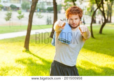 Hey you! Fitness model pointig fingers and looking at camera. Outdoor shot