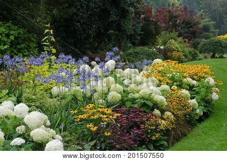 Large English perennial border in traditional garden