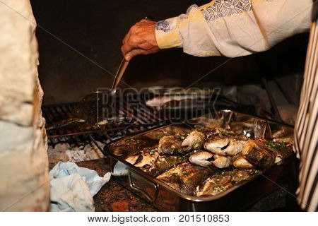 Fish grill / There are fish on the grill and grilled. An raw freshwater fish on the grill. Cooked in traditional style. Cooking of salted fish on a grill stove.