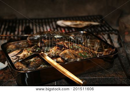 Fish grill / There are fish on the grill and grilled. An raw freshwater fish on the grill. Cooked in traditional style. Cooking of salted fish on a grill stove.