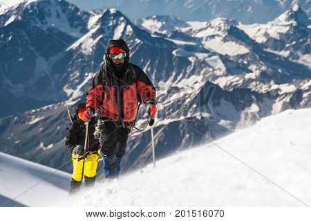 The climber climbs the snow-covered summit. The concept of overcoming difficulties and achieving the goal