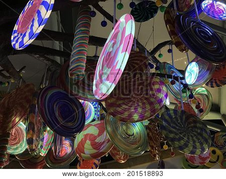 Numerous colorful lollipop candies hanging illumintated light